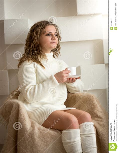 Portrait Of Beautiful Woman In Socks And Sweater Drinking
