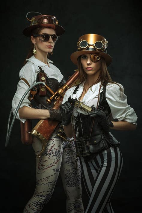 two girls dressed in the style of steampunk with arms