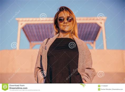beautiful happy woman in sunglasses standing at the sea