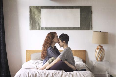 Romantic Lesbian Kissing On Girlfriend S Forehead While Sitting On Bed
