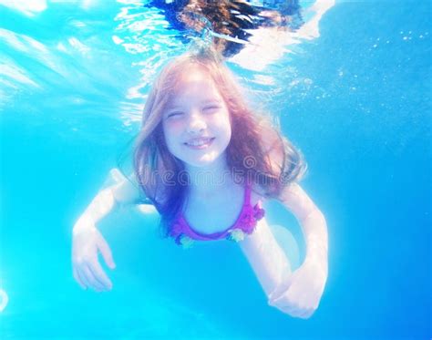 glückliches junges mädchen mit langhaarigem underwater im pool