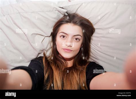 teenage 13 year old girl posing for a pretend selfie in her bedroom