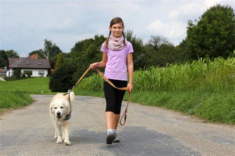 Mujer Joven Que Corre Con Su Perro En Un Camino De Tierra