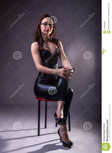 seksowna młoda kobieta w lateksie na krześle i gorseciku obraz stock obraz złożonej z
