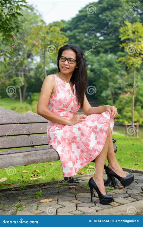 happy mature asian woman relaxing at the park outdoors stock image