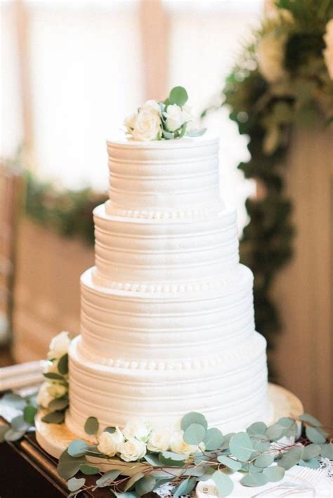 4 tier buttercream wedding cake with white flowers and