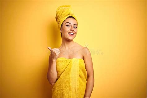 Young Beautiful Woman Wearing Towel After Shower Over Isolated Yellow