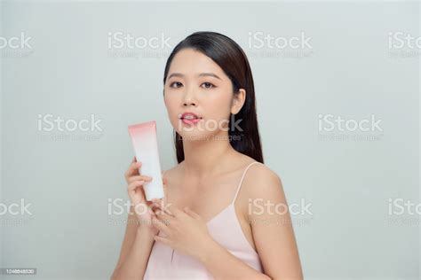 beautiful woman face portrait holding and presenting cream tube product