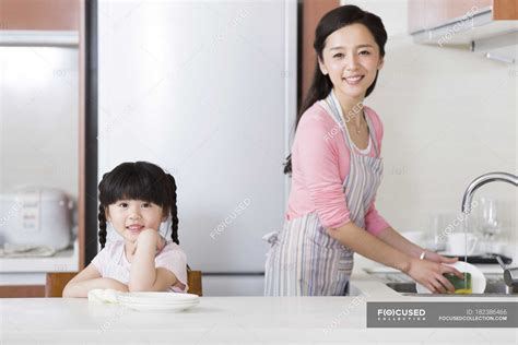 Chinese Mother And Daughter Washing Dishes In Kitchen — Domestic Life