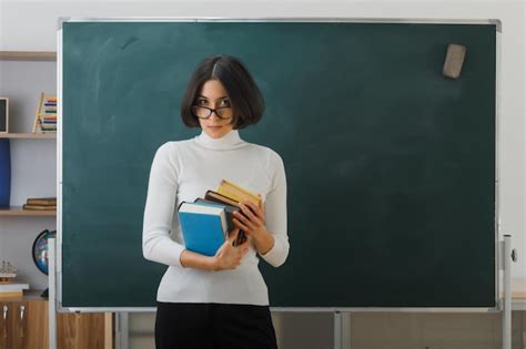 Free Photo Confident Young Female Teacher Wearing Glasses Holding