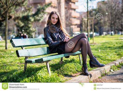 belle femme s asseyant sur le banc en parc image stock