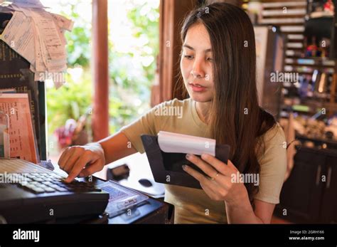 Young Asian Woman Cashier Checking Order Customer And Pressing Cash