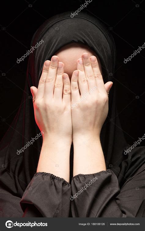 young muslim woman covering face hands stock photo  fotoeventstock