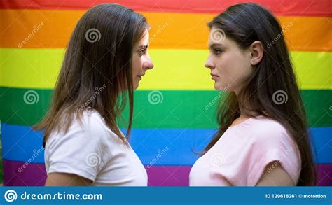 Two Beautiful Lesbians Standing On Rainbow Flag Background Minority