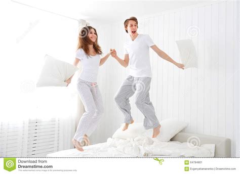 Happy Couple Jumping And Having Fun In Bed Stock Image