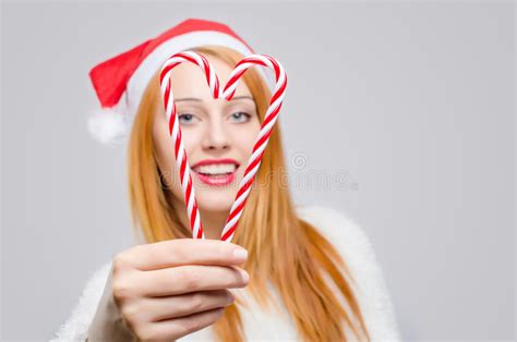 Beautiful Young Woman With Santa Hat Smiling Holding Candy Canes In