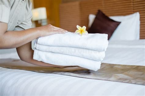 A Hotel Maid Stacked Towels On The Bed And Placed Flowers On The Towels