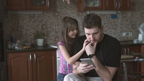 happy couple at home in kitchen at breakfast using smartphone together browsing online having