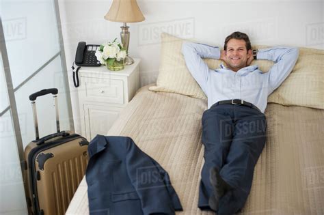 businessman relaxing  bed  hotel room stock photo dissolve