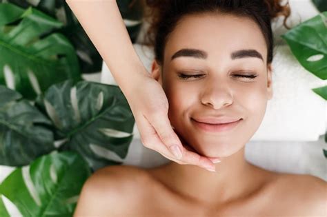 Premium Photo African American Woman Enjoying Face Massage With