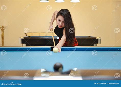 Beautiful And Asian Woman In Black Dress Playing Billiard Or Snooker On