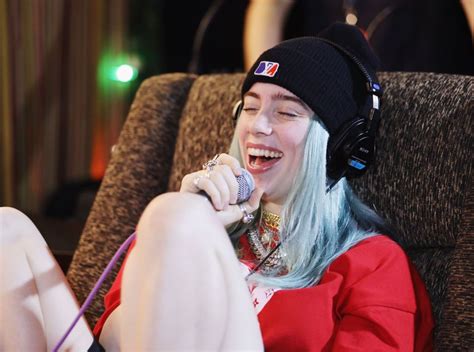 woman  white hair wearing headphones  singing   microphone  sitting   chair