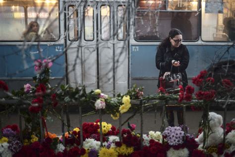 A Woman Pauses At A Makeshift Memorial To Victims At The