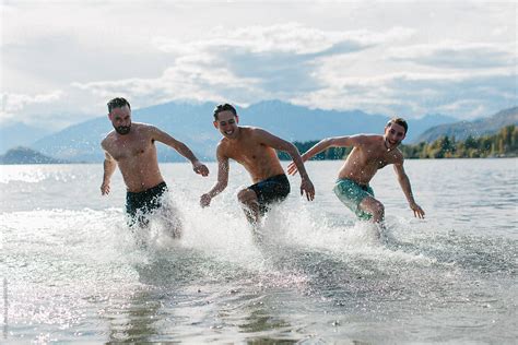 Three Friends Splash Around In The Warm Waters Of A Lake On A Late