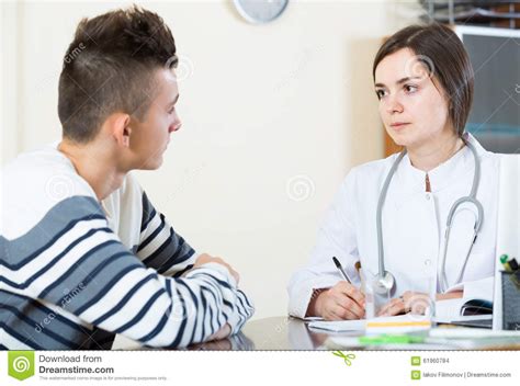 doctor receiving and questioning teen patient at office