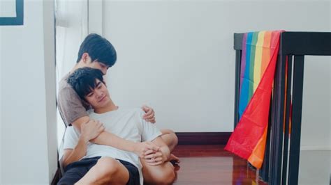 asian gay couple lying and hugging on the floor at home