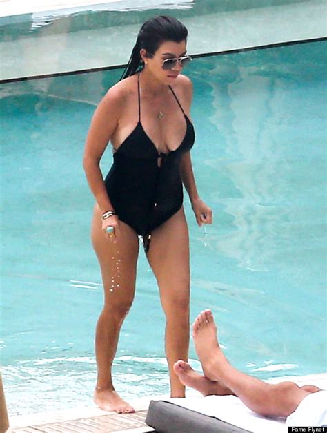 kourtney kardashian shows her curves in plunging one piece photos