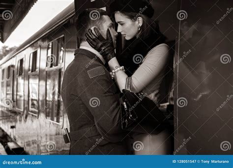 Vintage Couple Embracing On Railway Station Platform As Train Is About