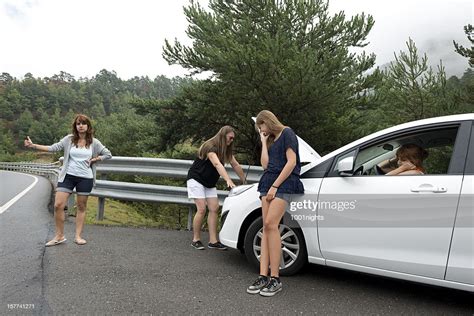 Four Women Hitchhiking Standing Beside Car With Hood Lifted High Res