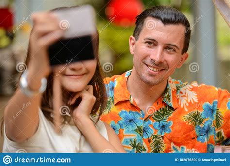 Happy Multi Ethnic Tourist Couple Taking Selfie Together At Restaurant