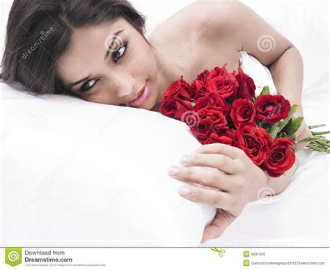 asian virgin in bed with red roses royalty free stock