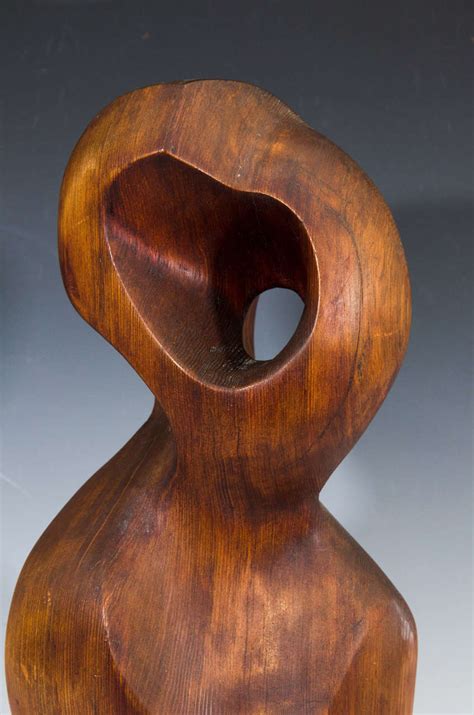 carved wood sculpture of a female figure by artist jean