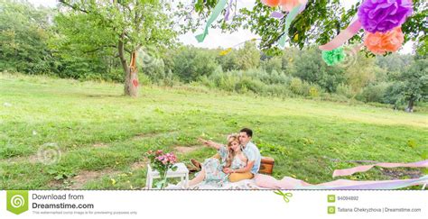 Beautiful Young Couple Having Picnic In Countryside Happy