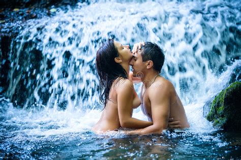 Couple Hugging And Kissing Under Waterfall Stock Image