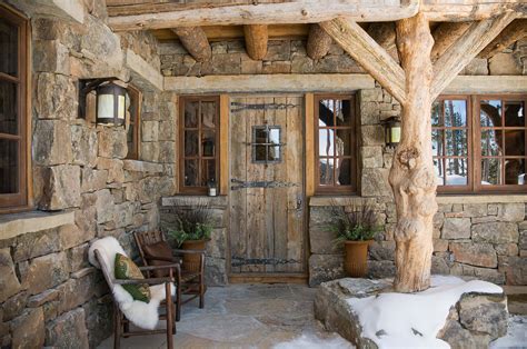 beautiful cabin entry rock walls rustic lighting small wooden windows natural wood porch