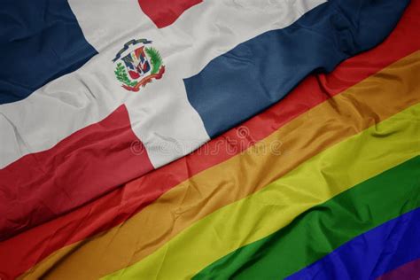 waving colorful gay rainbow flag and national flag of dominican
