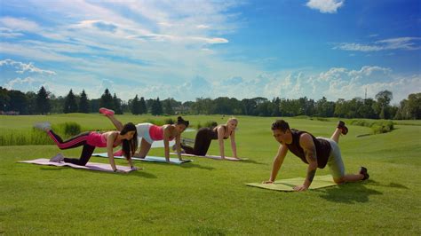 Outdoor Fitness Training Group Of People Doing Legs Exercise In Sunny