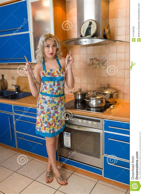 Attractive Naked Blond Housewife In An Apron Alone In A Home Kitchen