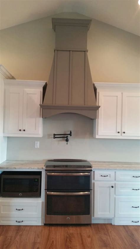 dove gray wooden hood vent  white cabinets  slate ge appliances white cabinets
