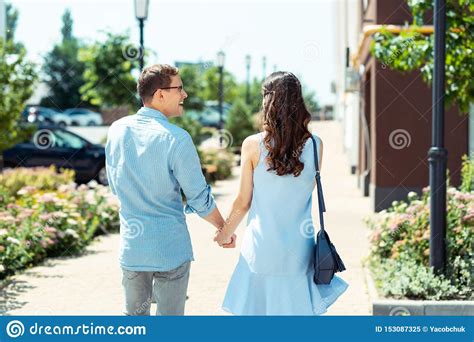 husband wearing glasses laughing while walking with wife