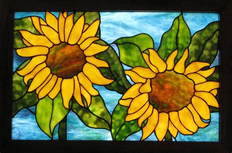 Two Yellow Sunflowers Are Depicted In A Stained Glass Window With Blue