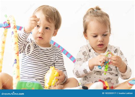 Dwoje Małych Dzieci Bawią Się Zabawkami Siedzącymi Na łóżku Brat I