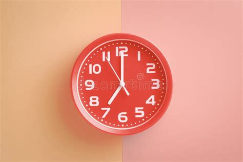 rode klok die zeven uur op een beige roze achtergrond tonen stock foto image  herinnering