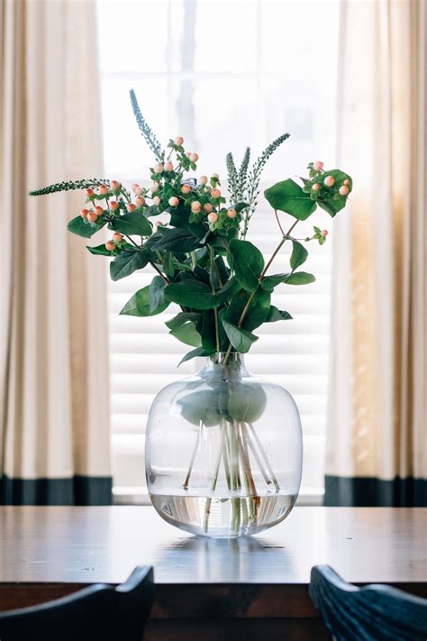 simple modern dining table centerpiece oversized clear glass vase  greenery modern