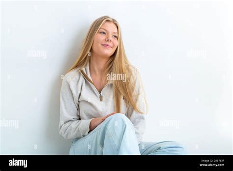 portrait of a 19 year old blonde woman leaning against a white