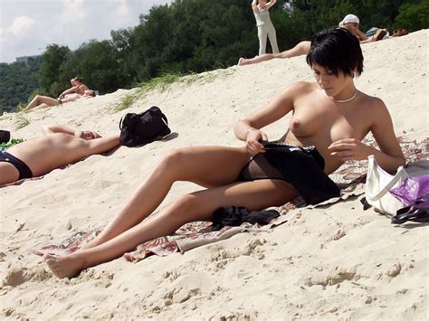 Short Haired Brunette Is Undressing At Public Beach